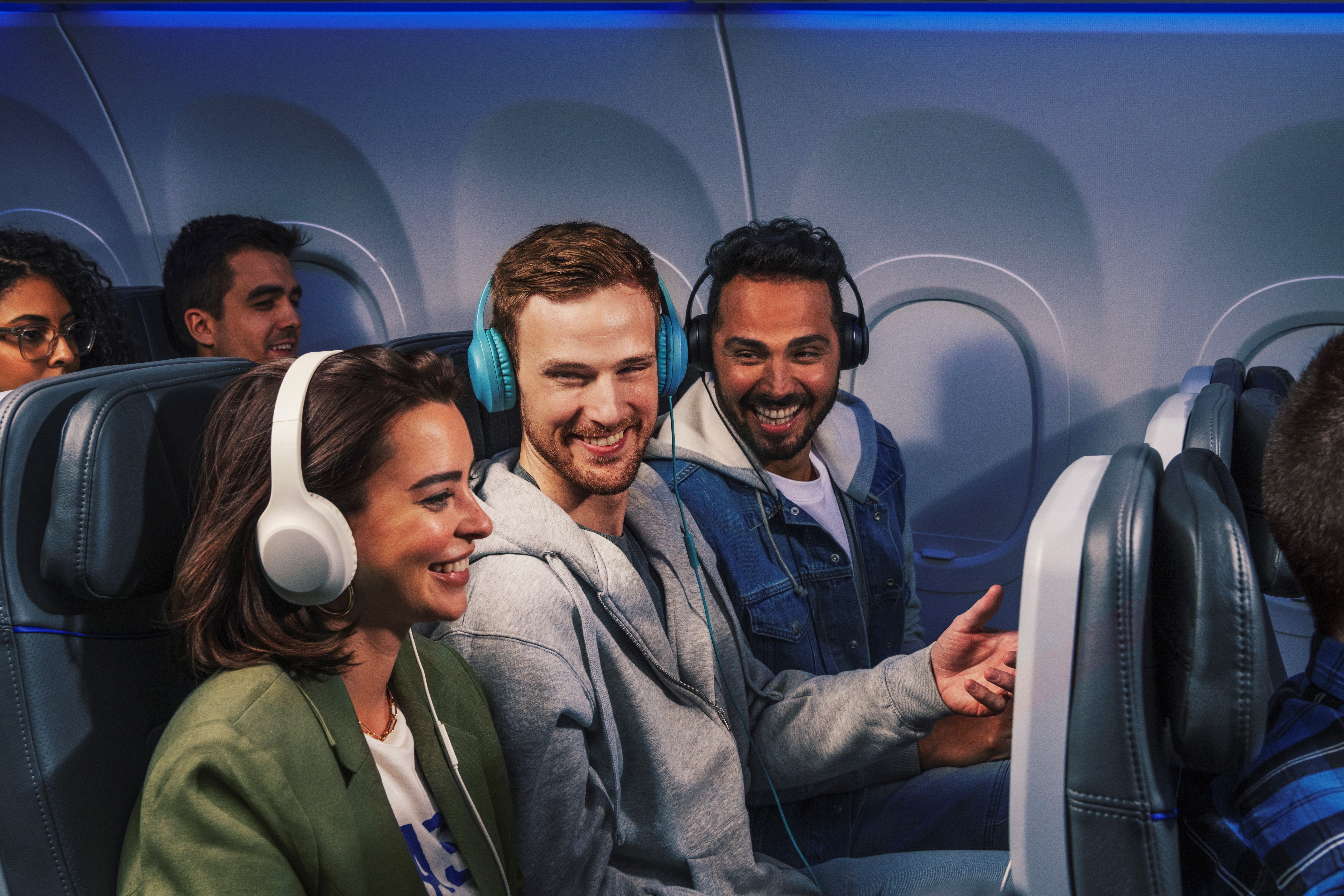 Passengers on a plane wearing headphones, using Blueprint Watch Party.