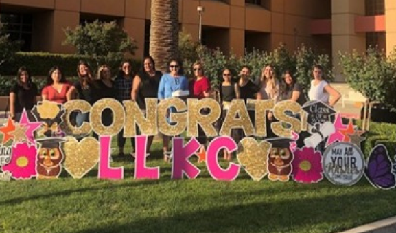 Members of Latina Leaders of Kern County standing in front of a Congrats sign