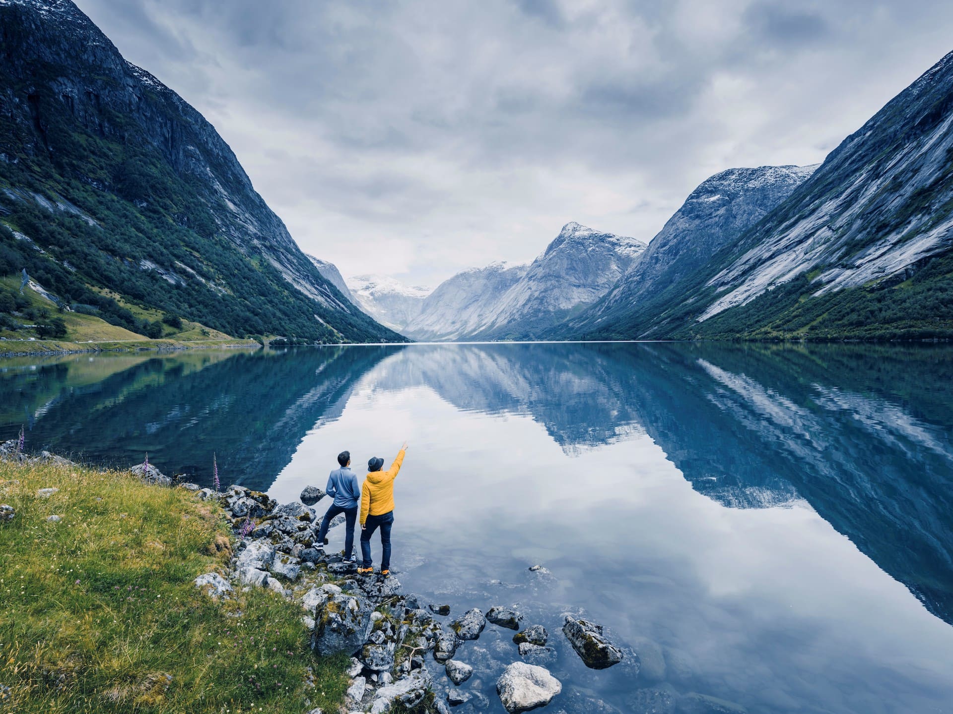 Friends admiring the view on the banks of a Norwegian fjord, Norway