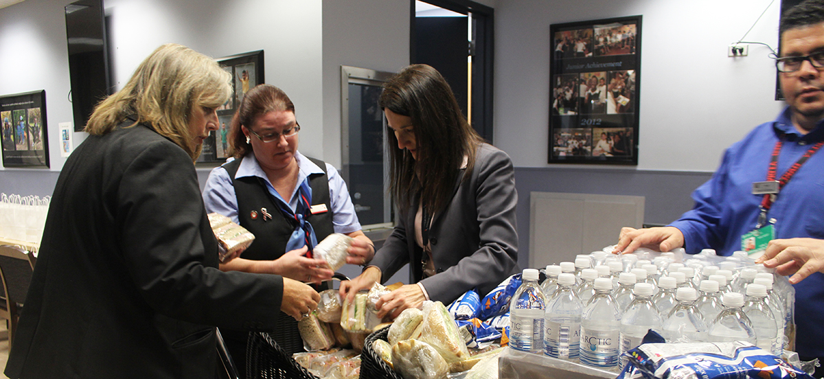 Crew members work to provide food and water to waiting passengers.