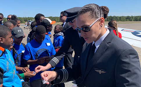 In the foreground, First Officer Tammy Binns distributes wings to participants. Behind her is First Officer Heath Bowers and First Officer Cory Glenn.