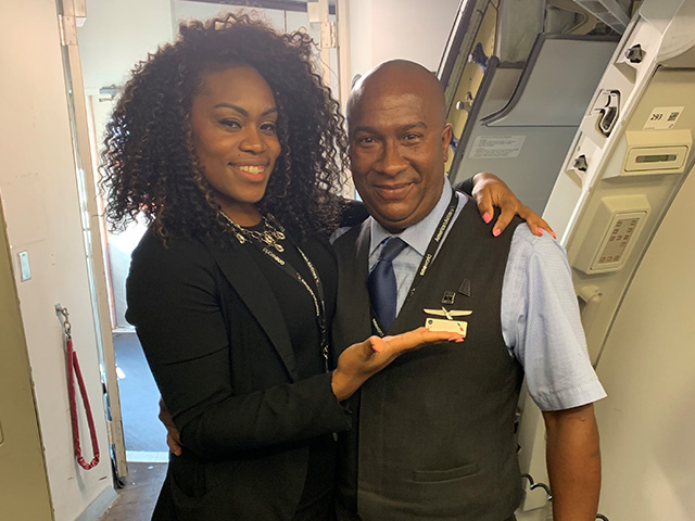 Senior Flight Service Manager Sara Harrison-Bell presents PHL-based Flight Attendant Jose Mariani-Gonzalez with his quarterly Chairman's Award pin.