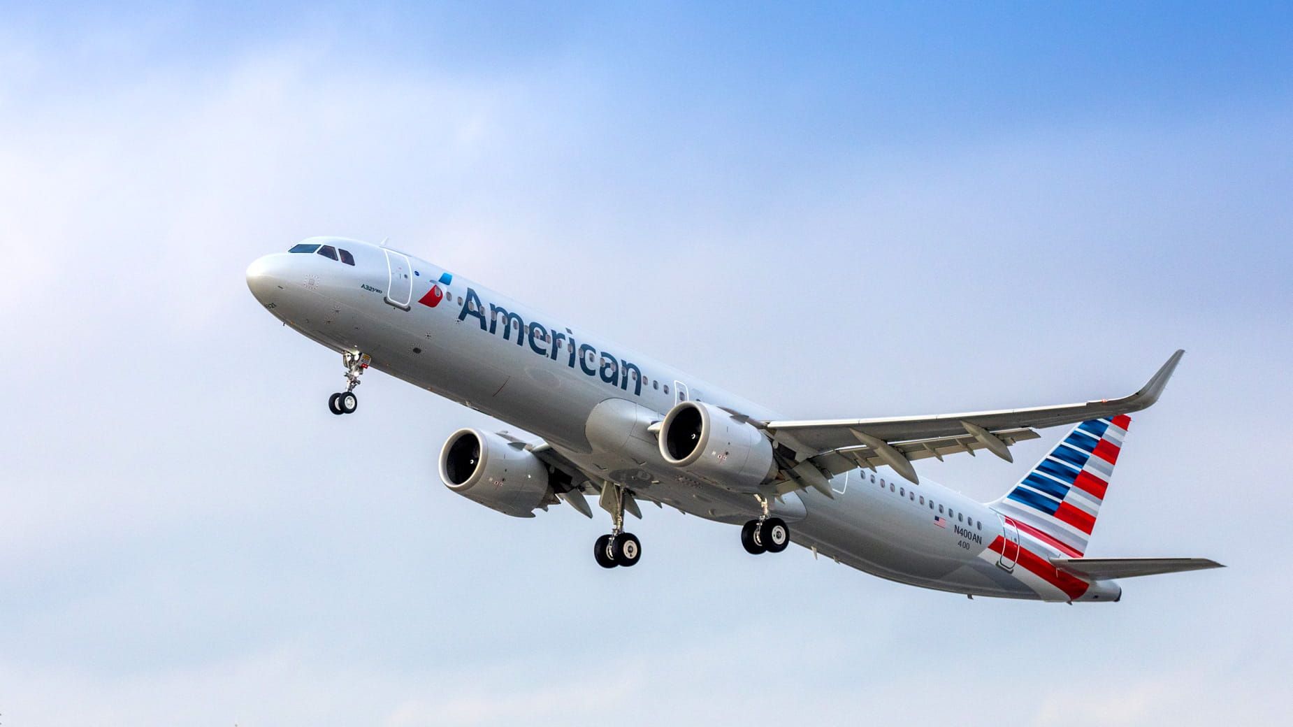 An American Airlines plane taking off, with clear skies in the background