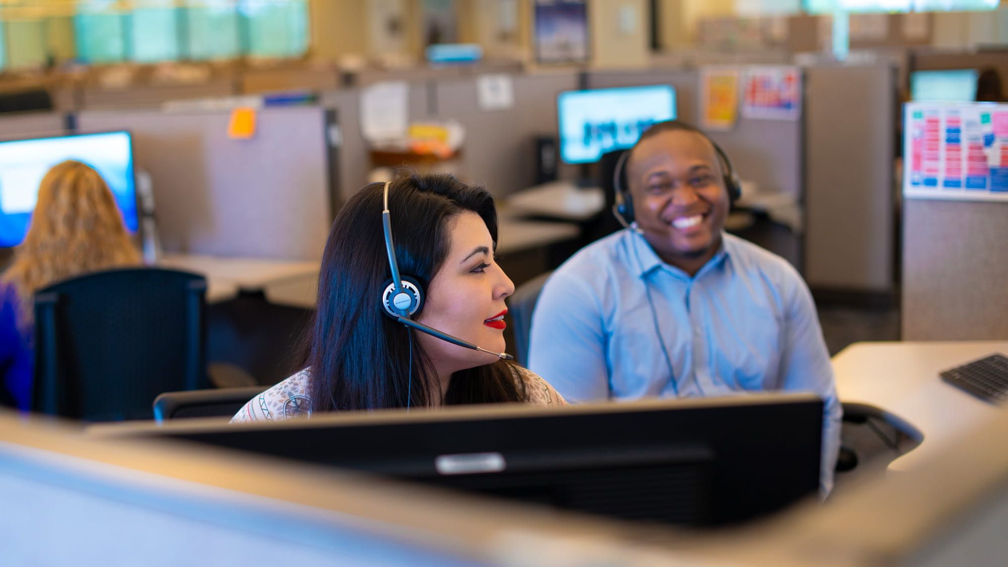 Team members in a call center smiling at each other