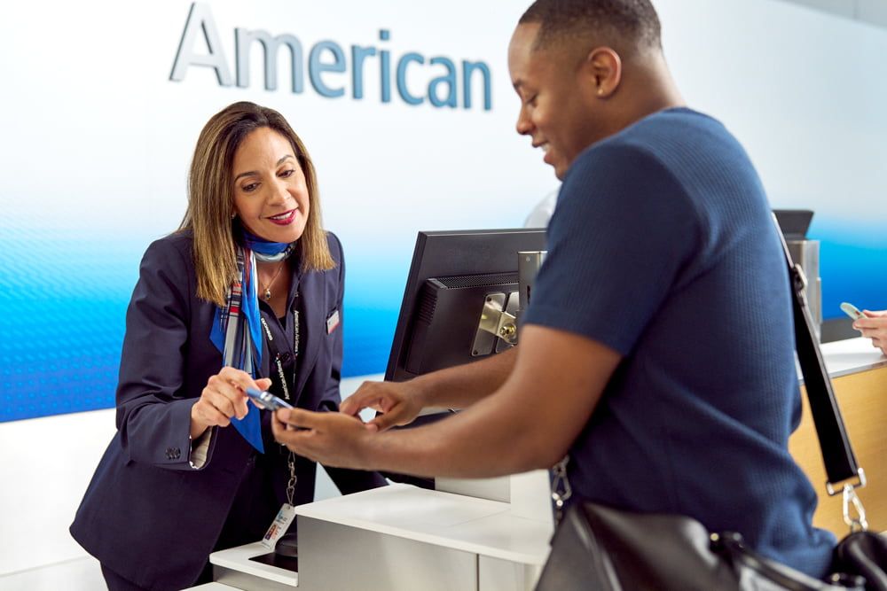 A helpful American Airlines agent helps a customer check in on their mobile phone