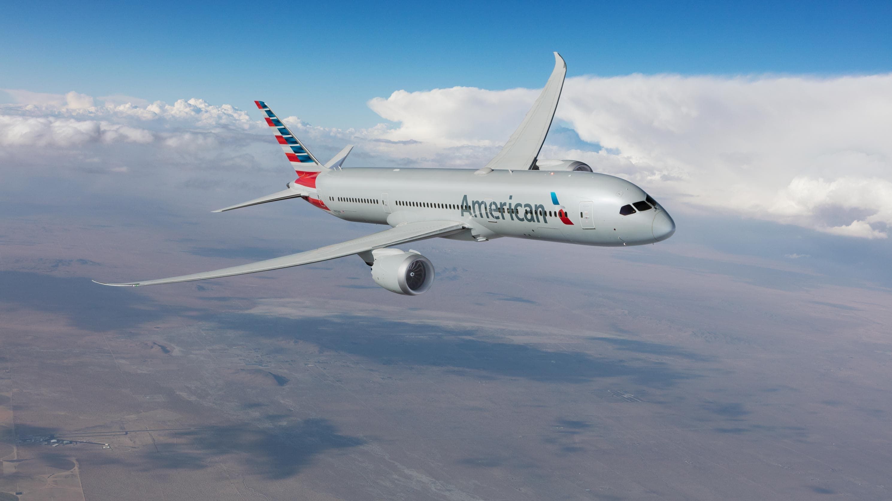 An American Airlines plane flies high over the clouds