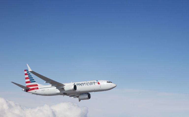An American Airlines plane flying over a clear blue sky